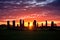 silhouette of a stone circle against a vivid sunset sky