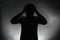 Silhouette of stressed man on dark background