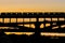 Silhouette of a subway bridge with a passing subway train on a background of sunset