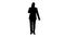 Silhouette Successful man in suit speaks on phone and walks.