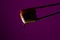 Silhouette of succulent roll between chopsticks on a colored background, drops of soy sauce dripping from sushi, food background,