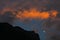 Silhouette of the summit of beautiful Gemu holy mountain and moon in flaming evening glow, Yunnan, China