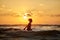 Silhouette at sunset.girl in the sunset.silhouette jump. Silhouette life and activity on the beach at dusk.