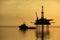 Silhouette of supply vessel and drilling platform