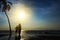 Silhouette of surf man stand with a surfboard and coconut palm.