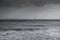 Silhouette of surfer in waves with famous Chauveau lighthouse,