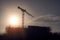Silhouette of a tall crane and construction site for commercial office of residential property. Construction industry. Modern