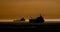 Silhouette tanker at anchor at sunset