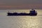 Silhouette of a tanker at sunset in sea.