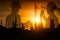 Silhouette of team engineer working at petrochemical oil refinery in sunset