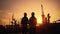 Silhouette of Teams engineer and foreman working at petrochemical oil refinery in sunset