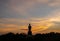 Silhouette technique under golden twilight evening sky with Walking Buddha statue in Thailand