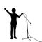 Silhouette teenage boy singing into microphone.