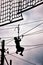 Silhouette of a teenage boy ziplining on zip line.