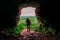 Silhouette of a teenager girl standing by a cave entrance, beautiful nature in the background. Travel, holiday and adventure