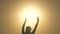 Silhouette of a teenager in palms of sun star. child plays, catches sunlight with his hands. concept of peace, love