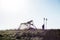 Silhouette of tent and hiker on top of a mountain.