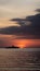 Silhouette of three boats with different sizes in the ocean at nightfall and orange sunset.