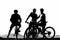 Silhouette of three male bicyclist on their mountain bikes having a rest