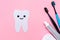 A silhouette of a tooth carved out of felt with a smiling cartoon face, next to an electric toothbrush, mouth freshener