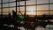 Silhouette of a tourist guy watching the take-off of the plane standing at the airport window at sunset in the evening