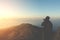 silhouette tourist man shoot photo on peak of mountain with vintage light