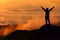 Silhouette tourist man spread hand on top of mountain.