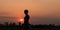 Silhouette tourist woman standng on the walkway in the rice field in the countryside of Thailand.Waiting for sunset.