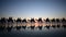 Silhouette of tourists on camel ride convoy on Cable Beach Broome Western Australia 02