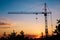 Silhouette tower construction crane on sunset background, copy