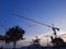 the silhouette of a tower crane that stands upright serves to carry out the lifting of building materials