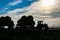 Silhouette of a tractor haystacks at sunset