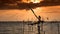 Silhouette of traditional fishing method using a bamboo square dip net with sunrise sky background