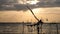 Silhouette of traditional fishing method using a bamboo square dip net with sunrise sky background