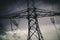 Silhouette of transmission towers, power tower, electricity pylon, steel lattice tower at twilight in Europe with moody dusk heavy