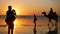 Silhouette of travel photographer photographing  tourist on camel ride convoy