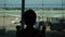 Silhouette of traveler little boy child baby looking at planes in window airport terminal