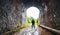 Silhouette traveler man explored in the ancient railway tunnel,