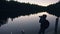 Silhouette traveler photographing scenic view in forest, river. Wood pier. One woman shooting nice dark magic night look