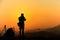 Silhouette of traveler when he is taking photograph on mountain at sunrise.