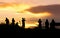 silhouette of traveler taking picture of landscape during sunrise