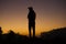 Silhouette of a traveler watching the dramatic sunrise in the valley with orange and purple sky in the background, Ooty.