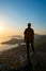 Silhouette of a traveler who stands on a cliff