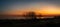 The silhouette of trees along the promenade of the west cliff in Ramsgate during a glorious sunset creating golden reflections in