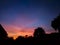 Silhouette of trees and cloudy colorful sky at sunrise