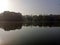 Silhouette of trees in fog. Tree reflection in the lake. Autumnal depression, anxiety