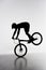 silhouette of trial biker performing front wheel stand