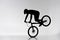 silhouette of trial cyclist performing front wheel stand