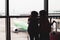 Silhouette of two asian child girls with backpack looking at plane and waiting for boarding in the airport