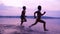 Silhouette of two boys running along the shore of river
